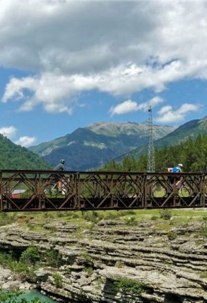 Cycling across a rustic bridge in Albania